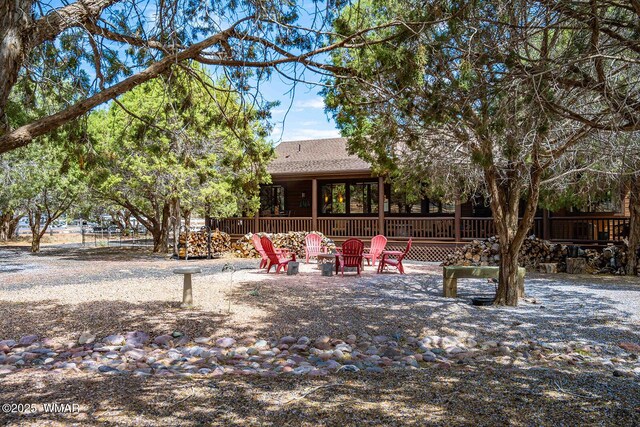 6757 Cheney Ranch Loop, Show Low, AZ 85901 - rear view of property featuring an outdoor fire pit, roof with shingles, and a wooden deck