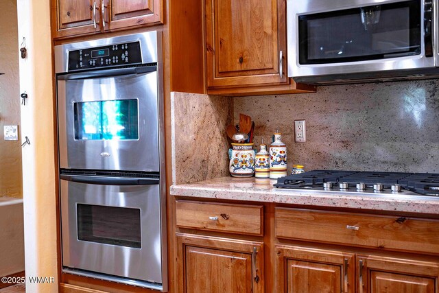 6757 Cheney Ranch Loop, Show Low, AZ 85901 - kitchen with appliances with stainless steel finishes, brown cabinetry, backsplash, and light stone counters