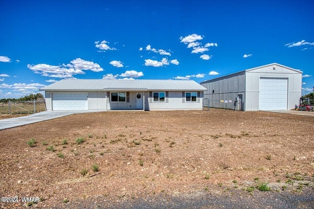 ranch-style home with metal roof, concrete driveway, an attached garage, and fence