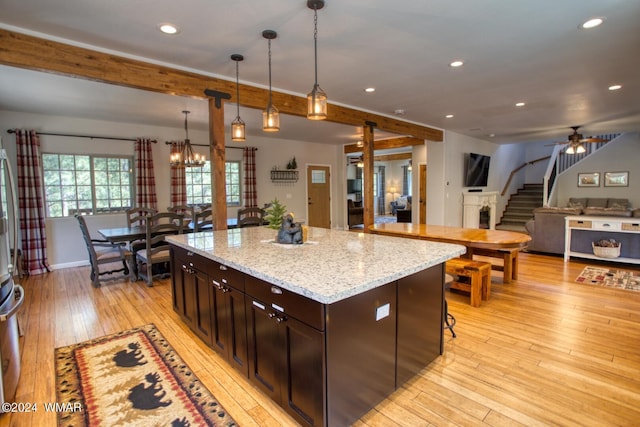 2020 S Pleasantview Dr, Show Low, AZ 85901 - kitchen featuring light wood finished floors, recessed lighting, hanging light fixtures, dark brown cabinetry, and a center island