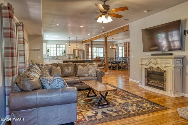 2020 S Pleasantview Dr, Show Low, AZ 85901 - living room featuring light wood-style floors, a ceiling fan, a chandelier, recessed lighting, and a fireplace