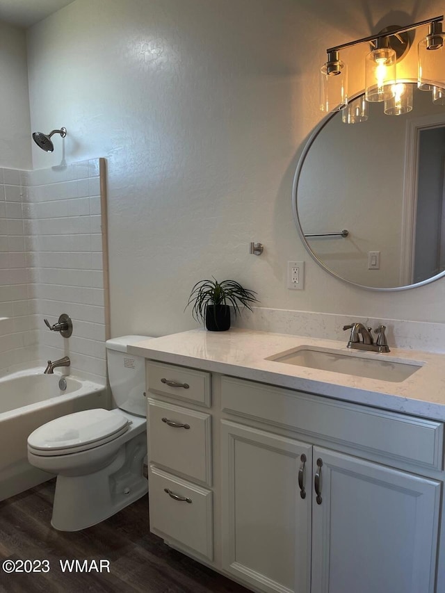 full bath with vanity, shower / washtub combination, wood finished floors, and toilet