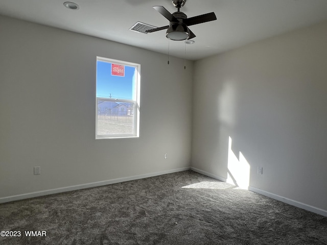 empty room featuring ceiling fan, baseboards, visible vents, and dark colored carpet