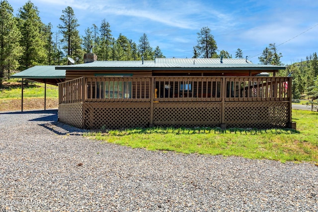back of property with gravel driveway and metal roof