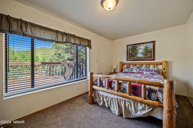 carpeted bedroom featuring baseboards and a textured ceiling