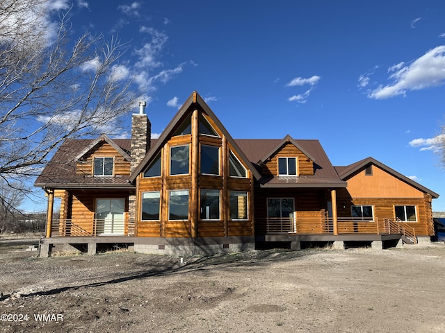 log home with crawl space, covered porch, a chimney, and metal roof