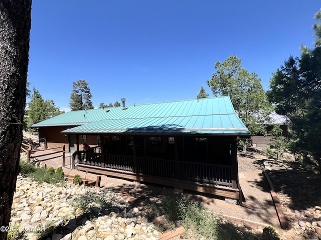 back of property with metal roof and a standing seam roof