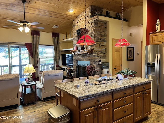 kitchen with open floor plan, stainless steel refrigerator with ice dispenser, dark wood-type flooring, and a center island