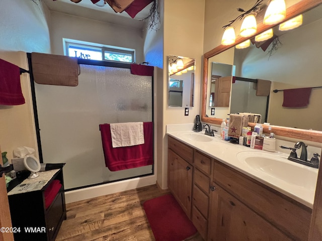 bathroom with a stall shower, a sink, and wood finished floors