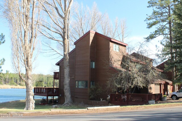 view of side of property featuring a deck with water view