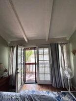 interior space featuring french doors, access to exterior, vaulted ceiling with beams, and wood finished floors