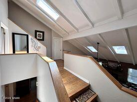 stairway featuring vaulted ceiling with skylight