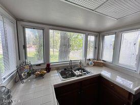 kitchen with tile patterned floors, light countertops, and a sink