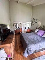 bedroom featuring beam ceiling and wood finished floors