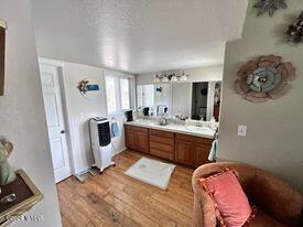 full bathroom featuring wood finished floors and double vanity