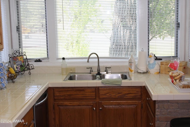 kitchen featuring a sink, tile countertops, and dishwasher