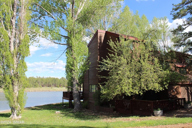 view of side of home featuring a water view and a yard