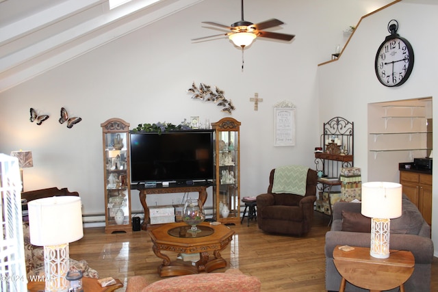 living area featuring ceiling fan, high vaulted ceiling, wood finished floors, and baseboard heating