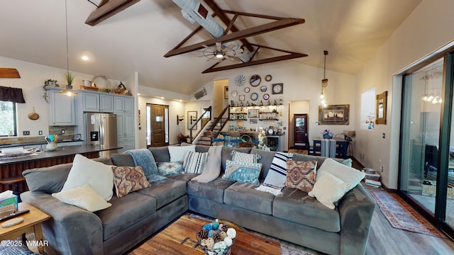 living room with a ceiling fan, high vaulted ceiling, wood finished floors, and stairway