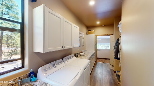 laundry room featuring cabinet space, separate washer and dryer, a wealth of natural light, and dark wood-type flooring