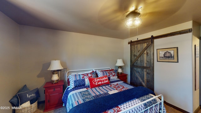 carpeted bedroom featuring baseboards, a ceiling fan, and a barn door