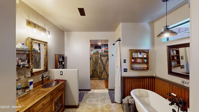 full bathroom featuring a soaking tub and vanity