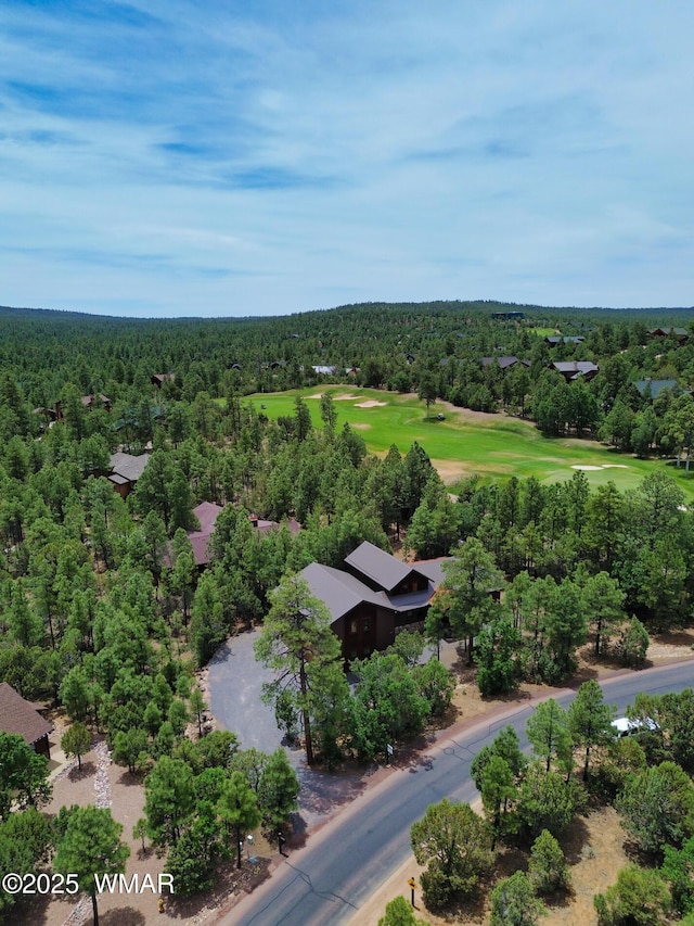 birds eye view of property with view of golf course and a forest view