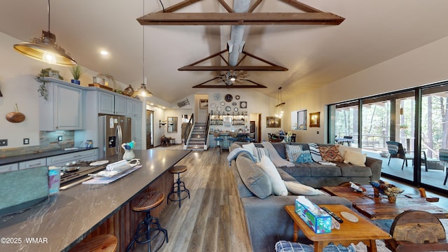 living room featuring high vaulted ceiling, ceiling fan, beam ceiling, and wood finished floors