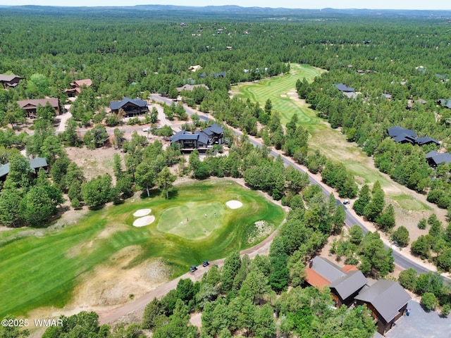 bird's eye view with view of golf course and a view of trees