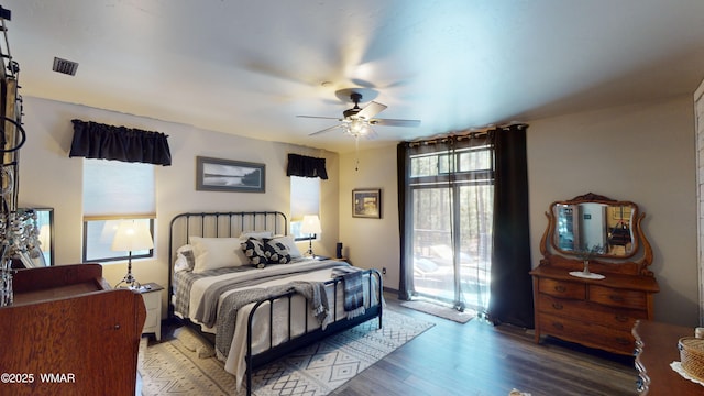 bedroom with access to outside, ceiling fan, visible vents, and wood finished floors