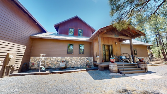 exterior space with metal roof and stone siding