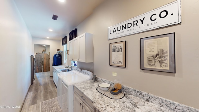 laundry area with washing machine and dryer, light wood-style floors, recessed lighting, a sink, and cabinet space
