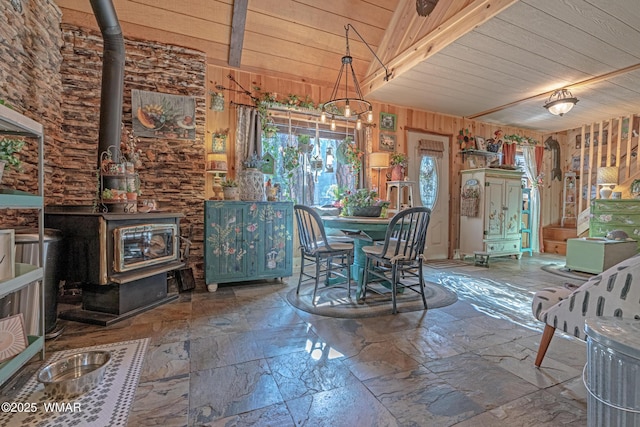 3738 Apache Trl, Pine, AZ 85544 - dining area featuring a wood stove, stone tile floors, wood ceiling, and wooden walls