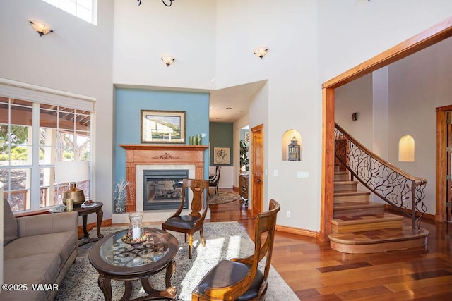 1961 S Canyon Ridge Trl, Show Low, AZ 85901 - living area with a towering ceiling, wood finished floors, a fireplace, baseboards, and stairway