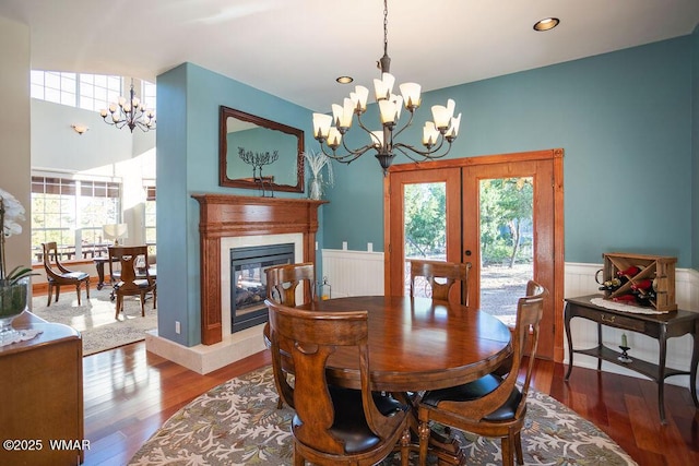 1961 S Canyon Ridge Trl, Show Low, AZ 85901 - dining area with a chandelier, a wainscoted wall, french doors, wood finished floors, and a glass covered fireplace