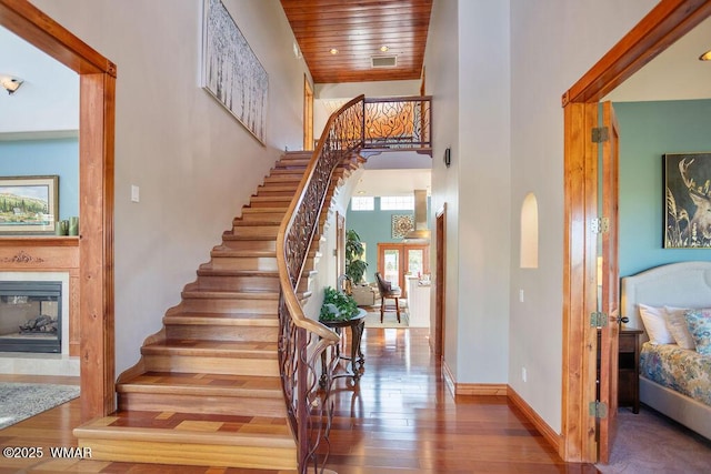 1961 S Canyon Ridge Trl, Show Low, AZ 85901 - stairs with a glass covered fireplace, a high ceiling, wood finished floors, baseboards, and wooden ceiling