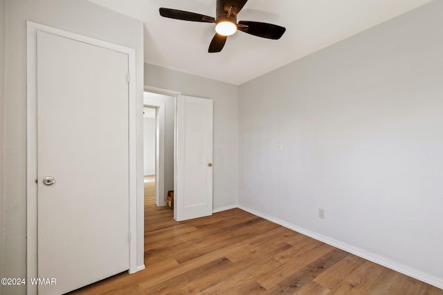 unfurnished bedroom featuring a ceiling fan, light wood-style flooring, and baseboards