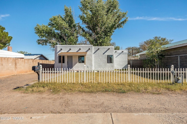 view of front of property with a fenced front yard and stucco siding