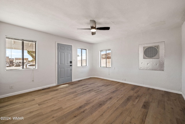 interior space featuring a textured ceiling, dark wood-style flooring, and baseboards