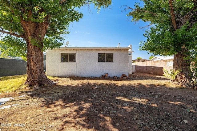 back of property with a fenced backyard and stucco siding