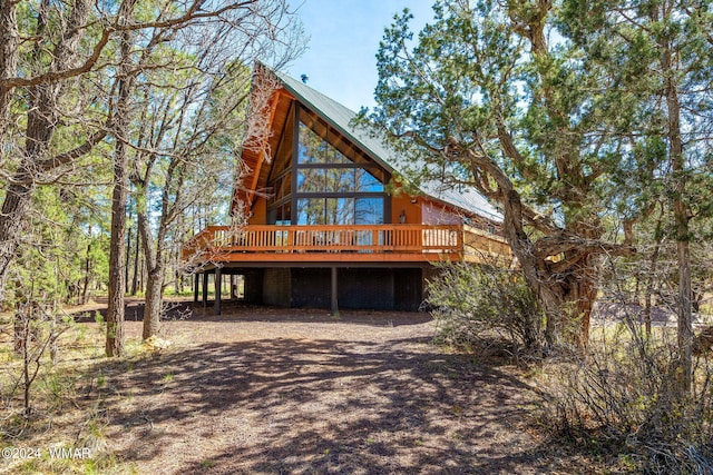 back of property featuring metal roof and a wooden deck