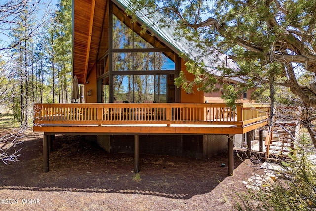 back of house with a wooden deck and stairs