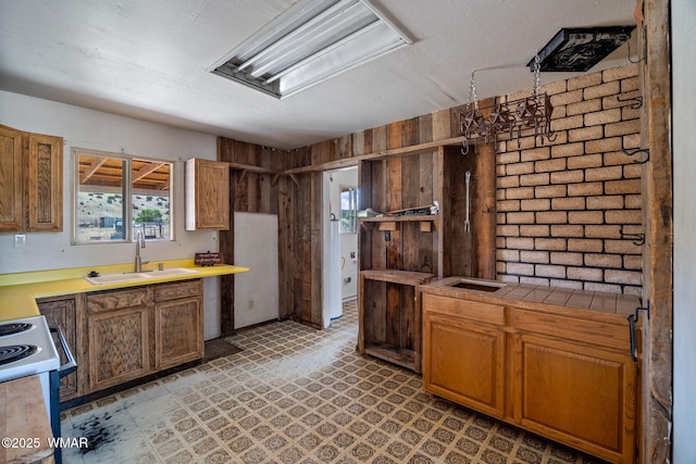 1720 E Becker Lane Loop, Springerville, AZ 85938 - kitchen with white electric range oven, light floors, wooden walls, and brown cabinetry