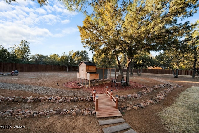 view of yard featuring an outbuilding, fence, and exterior structure