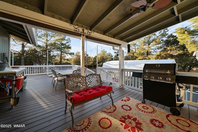 deck with outdoor dining area, ceiling fan, and area for grilling