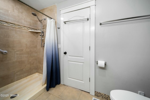 bathroom with a shower stall, toilet, and tile patterned floors