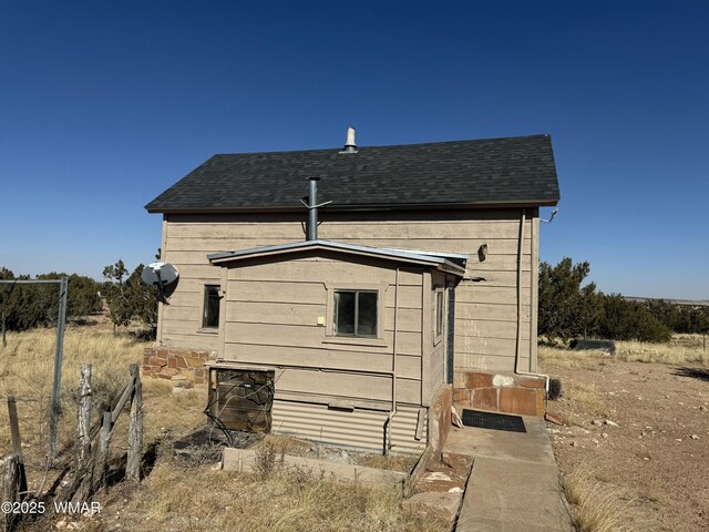 rear view of property with a shingled roof