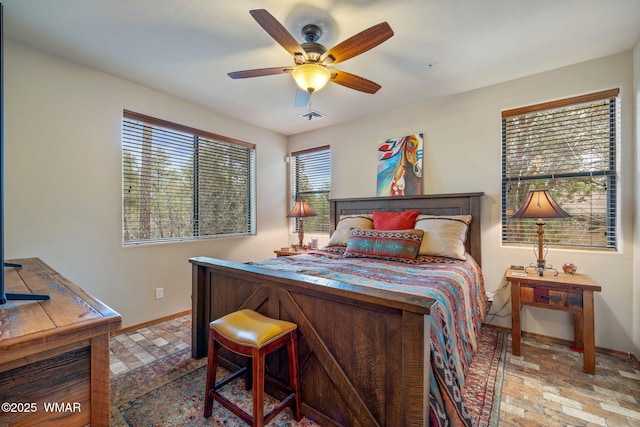 bedroom with a ceiling fan, brick floor, visible vents, and baseboards