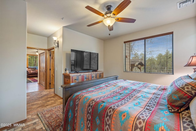 bedroom with baseboards, visible vents, and a ceiling fan