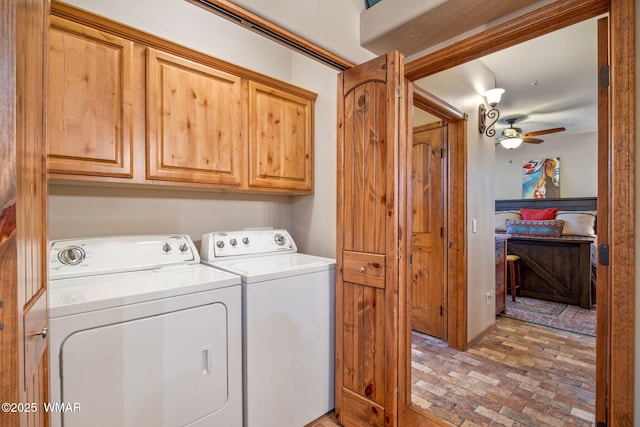 clothes washing area featuring cabinet space, washing machine and dryer, brick floor, and ceiling fan